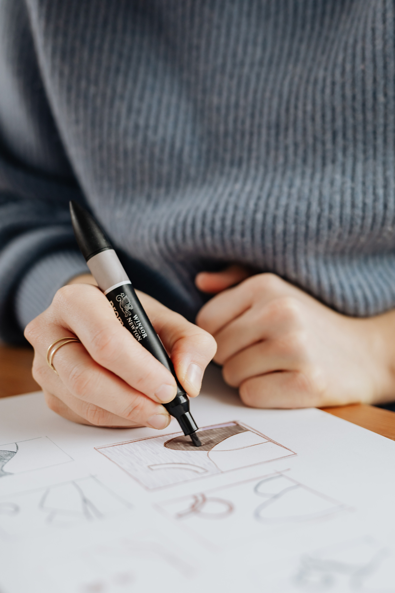 Crop female designer drawing on paper sheet